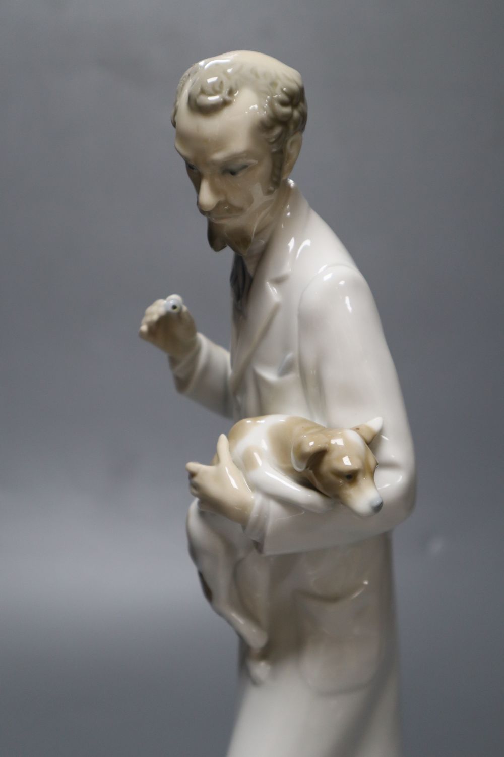 A Lladro figure, vet treating dog, 34cm